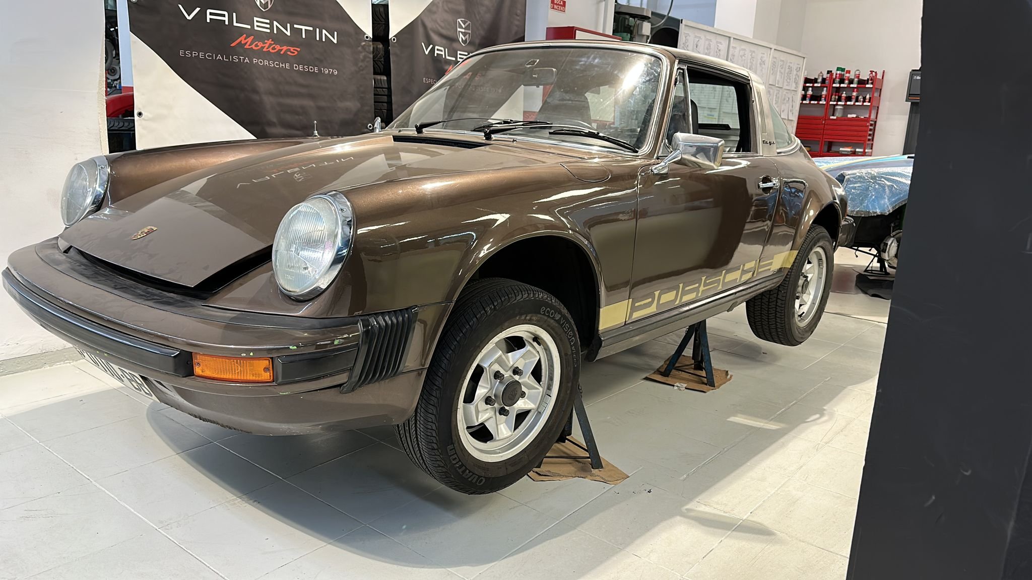 Porsche 911 2.7 S de 1975, marrón, sobre caballetes en el taller antes de la restauración
