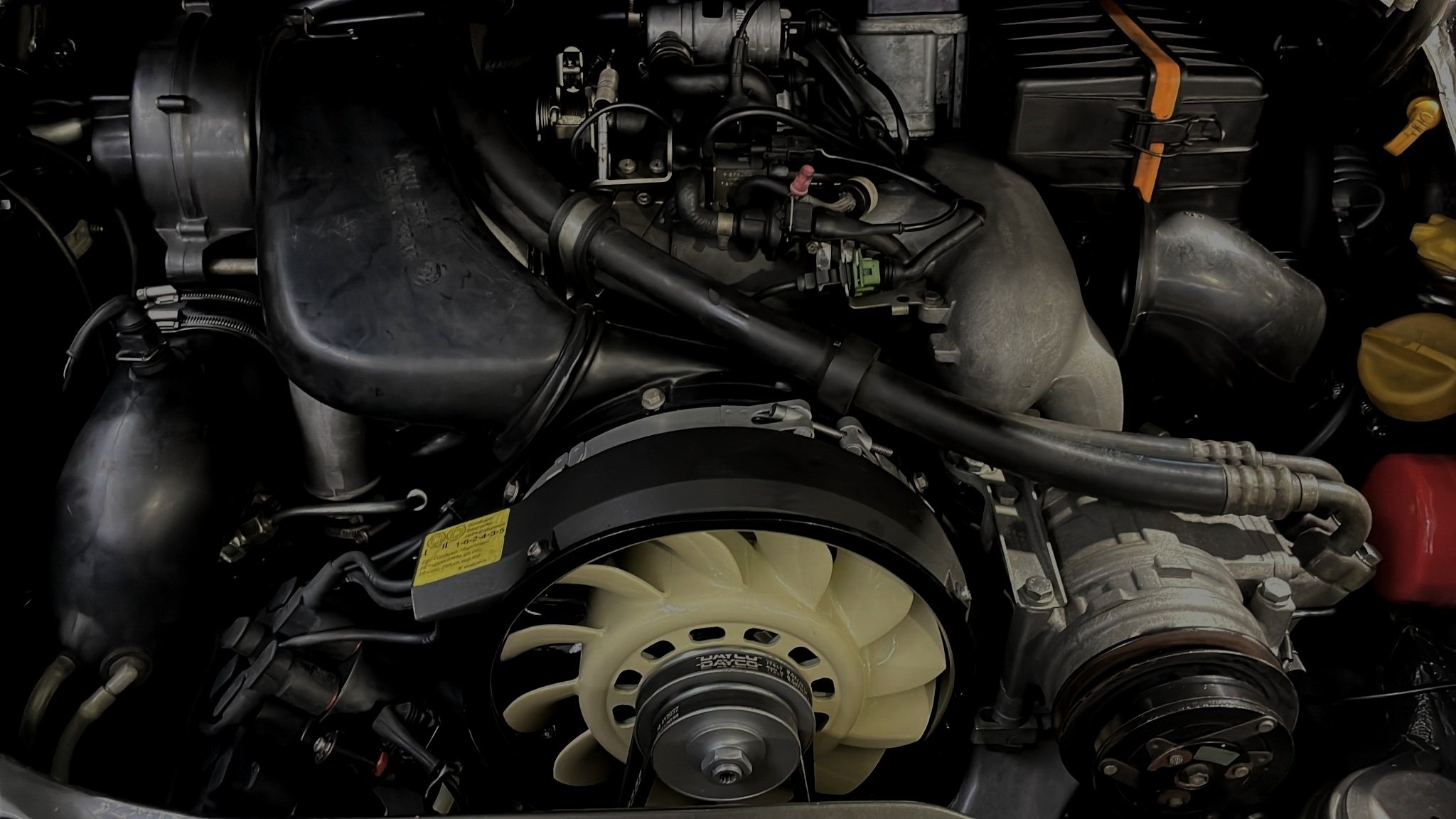 Vano motor de un 964, con el ventilador y el compresor del aire acondicionado a la vista