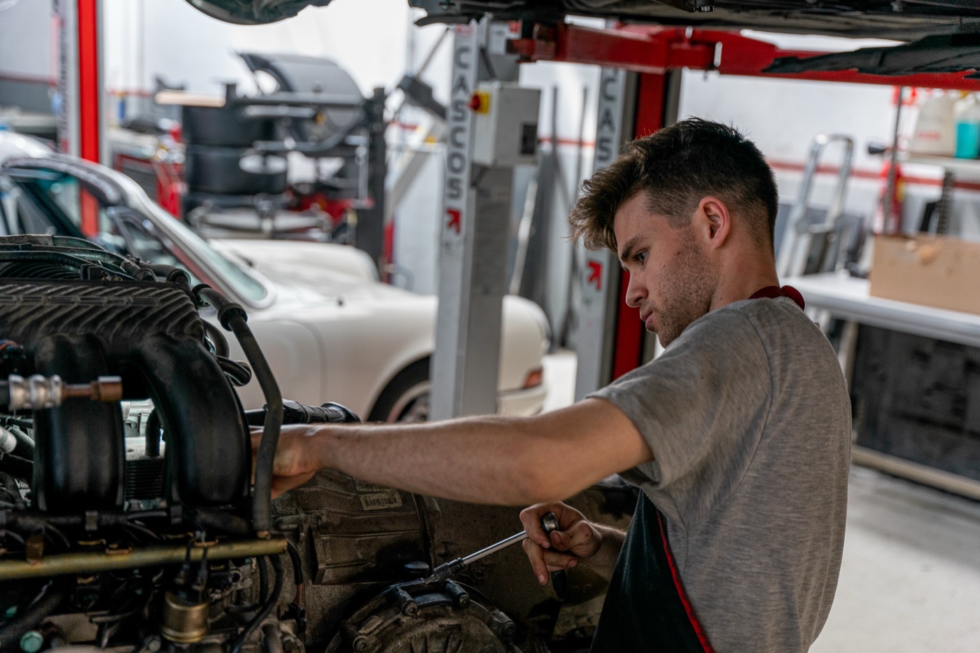 Mecánico trabajando en el motor de un Porsche 911 en el taller